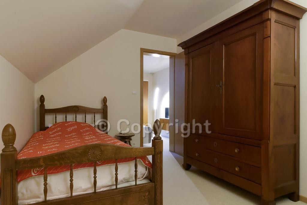 Chambre avec lit et grande armoire en bois