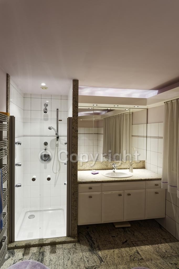 Salle de bains avec douche hydromassage et meuble vasque