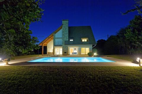 Maison d'architecte et piscine éclairées de nuit