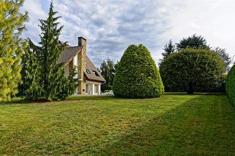 Jardin arboré de la propriété avec maison en arrière-plan